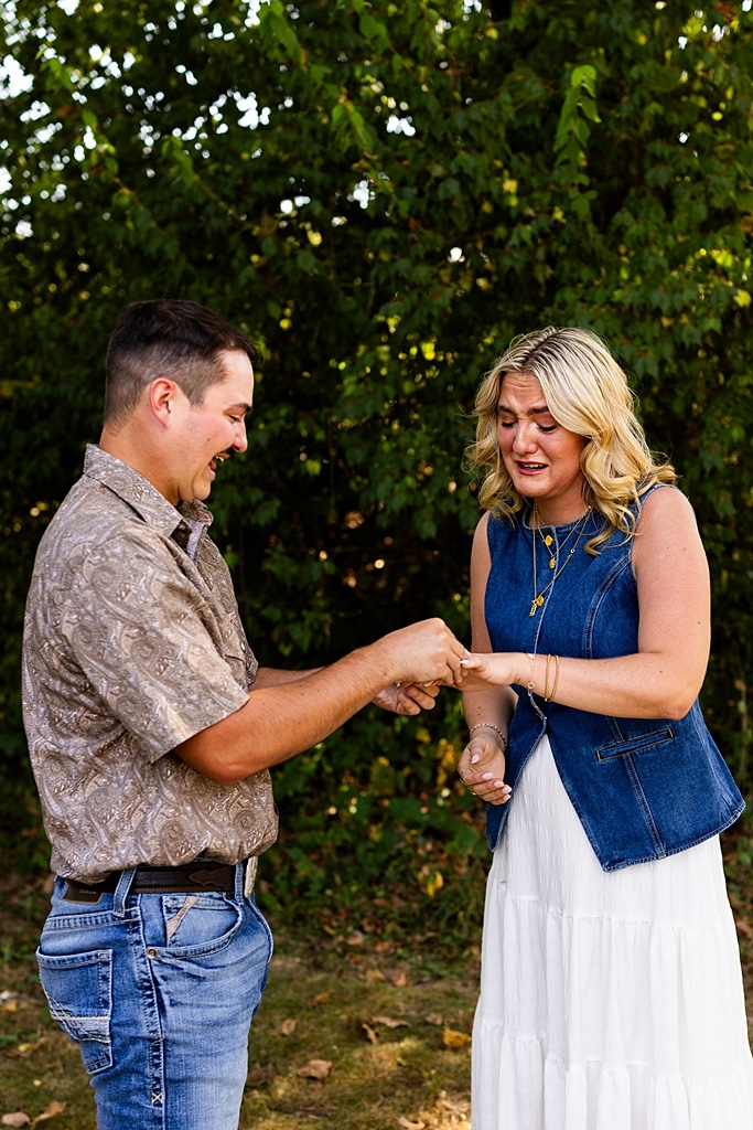 Tyler proposing to Rachel at Chandler Hill Vineyards in Defiance Missouri
Couple standing back to back moments before the surprise proposal
Rachel crying with joy as Tyler kneels during the proposal
Newly engaged couple hugging surrounded by vineyard scenery
Close up of engagement ring in front of rolling vineyard hills